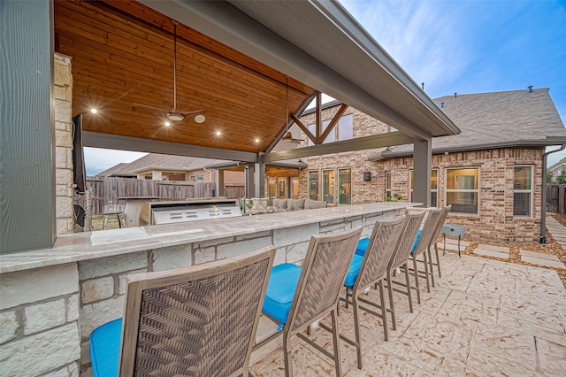 view of patio / terrace featuring an outdoor kitchen, a grill, and a bar