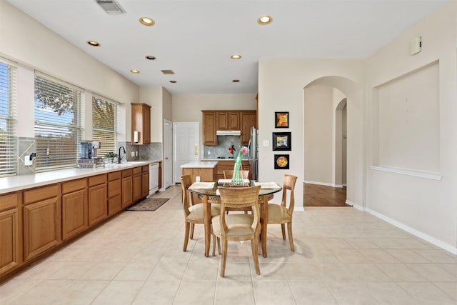 dining area with arched walkways, baseboards, visible vents, and recessed lighting