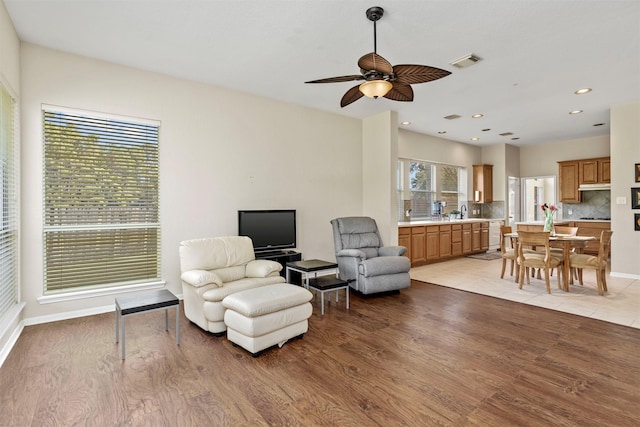 living area featuring recessed lighting, light wood-type flooring, visible vents, and baseboards