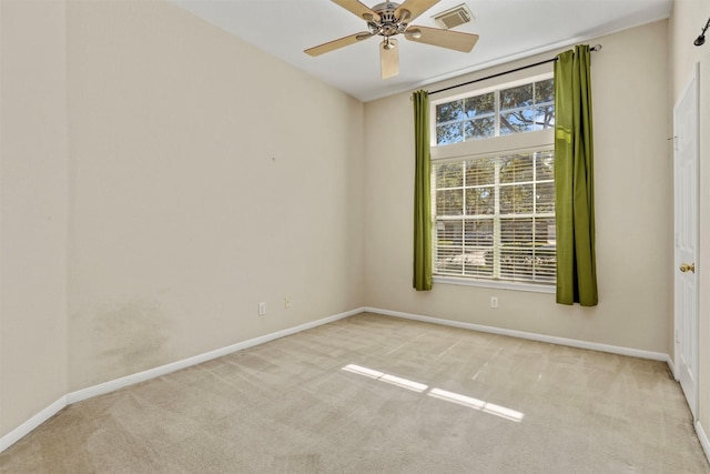 spare room with carpet, visible vents, ceiling fan, and baseboards