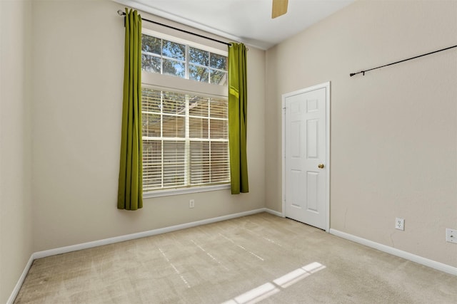 empty room with carpet, baseboards, and ceiling fan