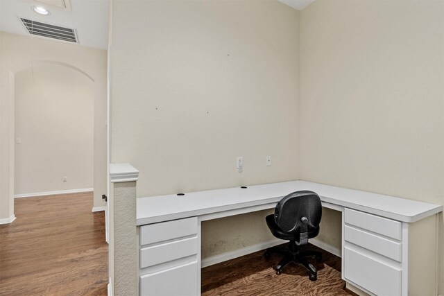 office area with baseboards, visible vents, wood finished floors, and built in study area