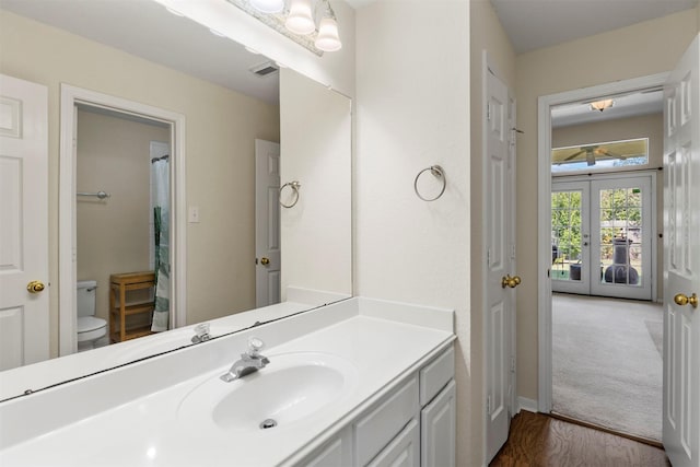 full bath with french doors, visible vents, vanity, and toilet