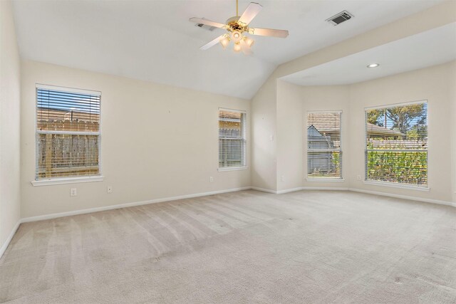 carpeted spare room with a healthy amount of sunlight, baseboards, visible vents, and a ceiling fan