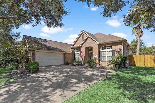 view of front of property with brick siding, fence, a garage, driveway, and a front lawn