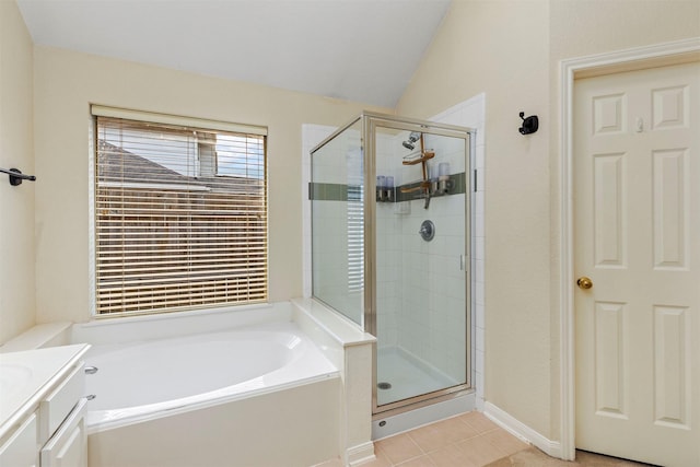 full bath with a stall shower, tile patterned flooring, vaulted ceiling, and a garden tub