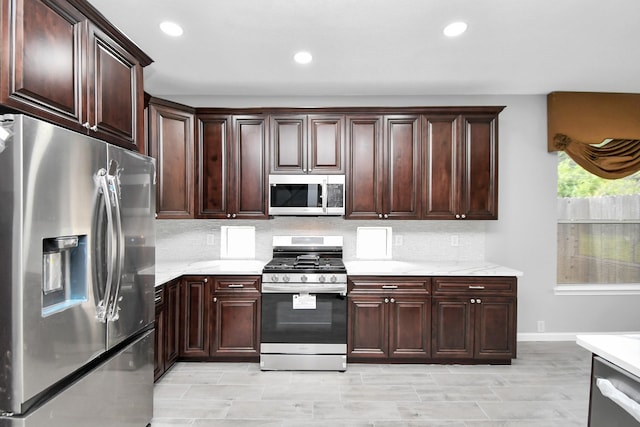 kitchen with appliances with stainless steel finishes, tasteful backsplash, light hardwood / wood-style flooring, and dark brown cabinets