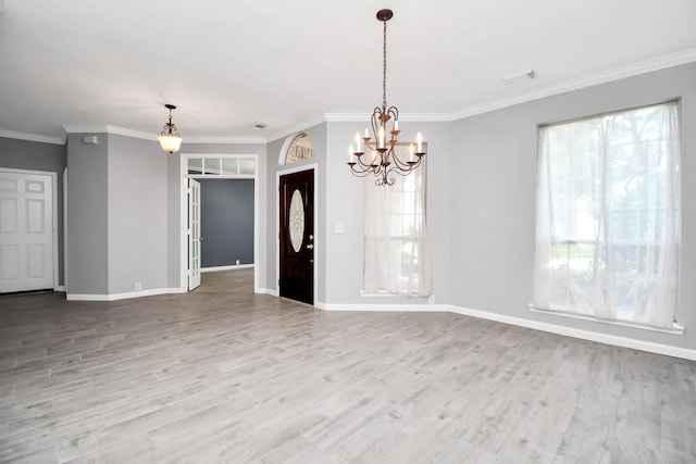 unfurnished room featuring wood-type flooring, ornamental molding, and a notable chandelier