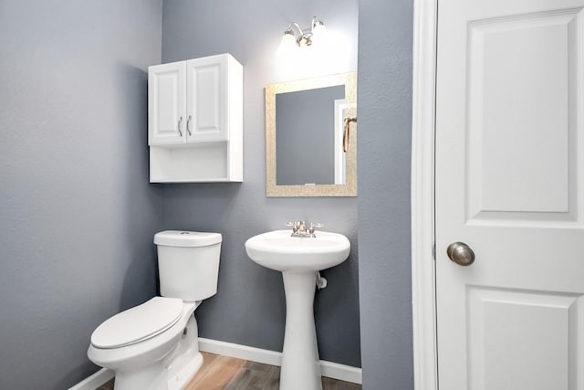 bathroom with hardwood / wood-style floors, toilet, and sink