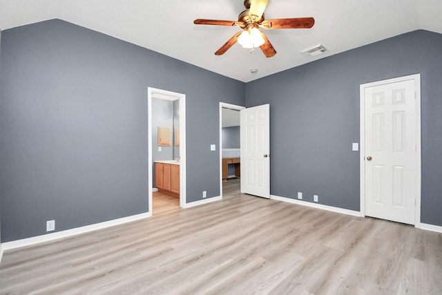 unfurnished bedroom featuring ceiling fan, ensuite bathroom, vaulted ceiling, and light hardwood / wood-style floors