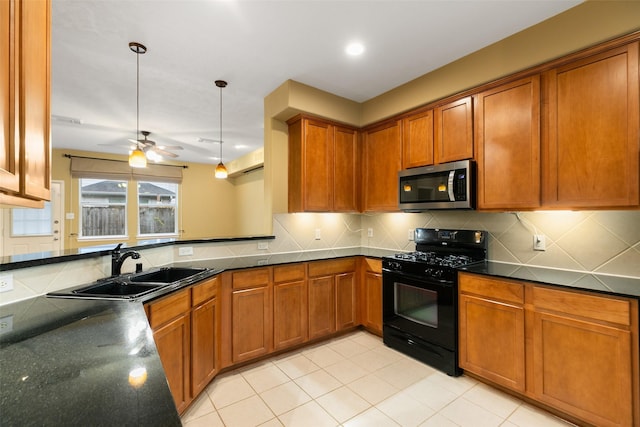 kitchen featuring black gas range oven, sink, hanging light fixtures, backsplash, and ceiling fan