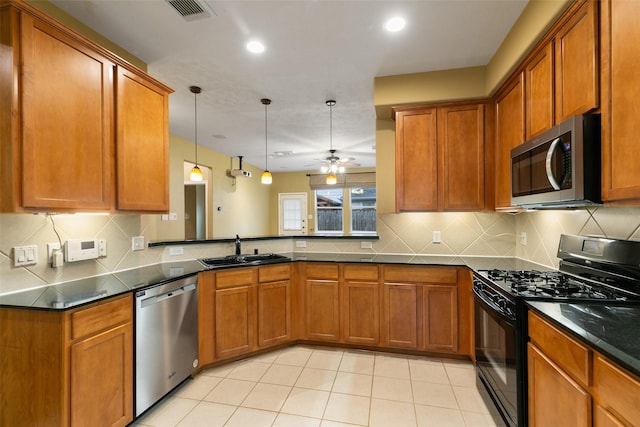 kitchen featuring pendant lighting, stainless steel appliances, sink, kitchen peninsula, and ceiling fan