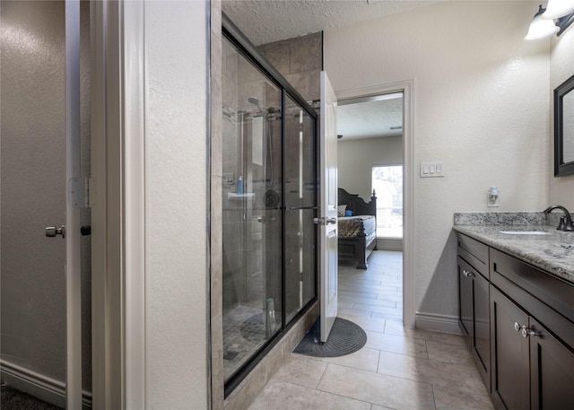 bathroom with tile patterned flooring, vanity, a shower with shower door, and a textured ceiling