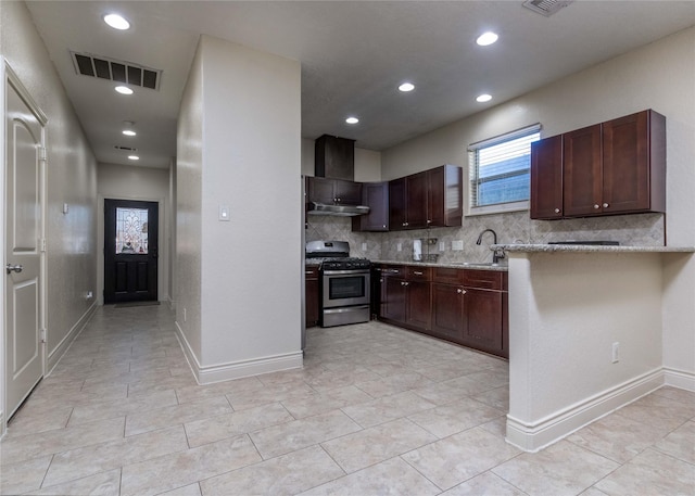 kitchen featuring decorative backsplash, light stone counters, sink, stainless steel range with gas cooktop, and light tile patterned flooring