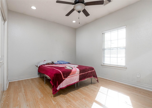 bedroom with light hardwood / wood-style floors and ceiling fan