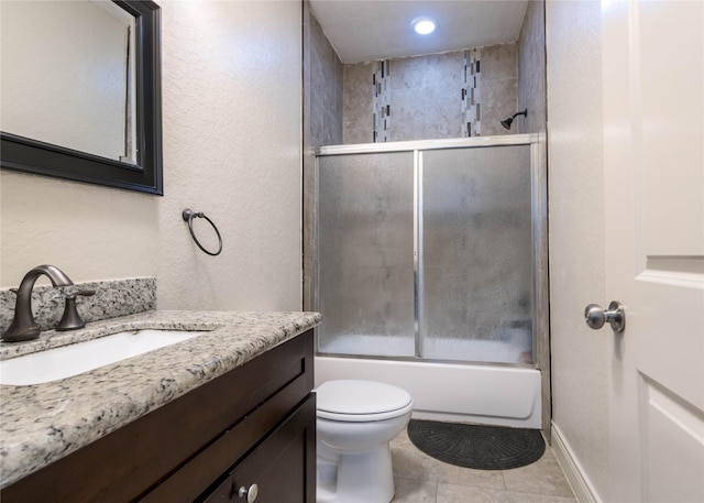 full bathroom featuring combined bath / shower with glass door, tile patterned floors, vanity, and toilet