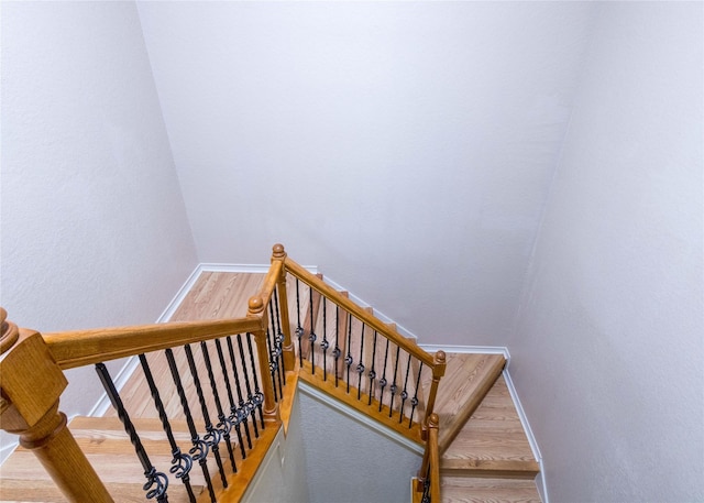 stairs featuring hardwood / wood-style floors