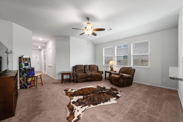 carpeted living room with ceiling fan and vaulted ceiling