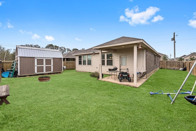 rear view of house featuring a yard, a patio area, and a storage shed