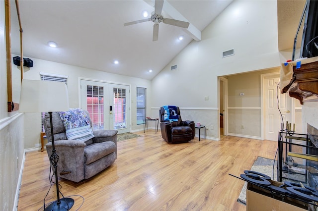 interior space featuring high vaulted ceiling, a fireplace, french doors, ceiling fan, and light hardwood / wood-style flooring