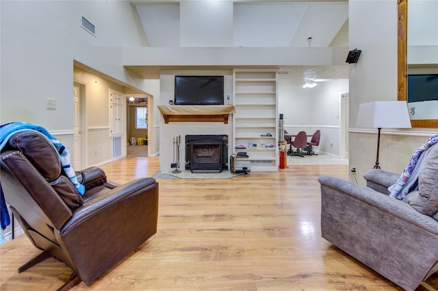 living room with high vaulted ceiling and light hardwood / wood-style flooring