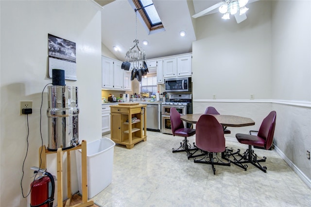 dining area with lofted ceiling with skylight and ceiling fan