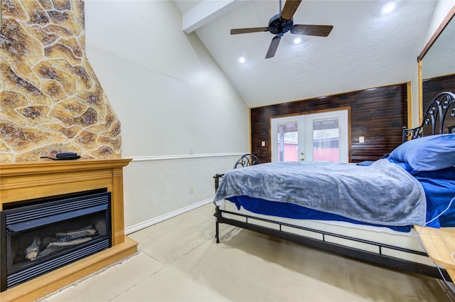 bedroom with wooden walls, a fireplace, ceiling fan, and french doors