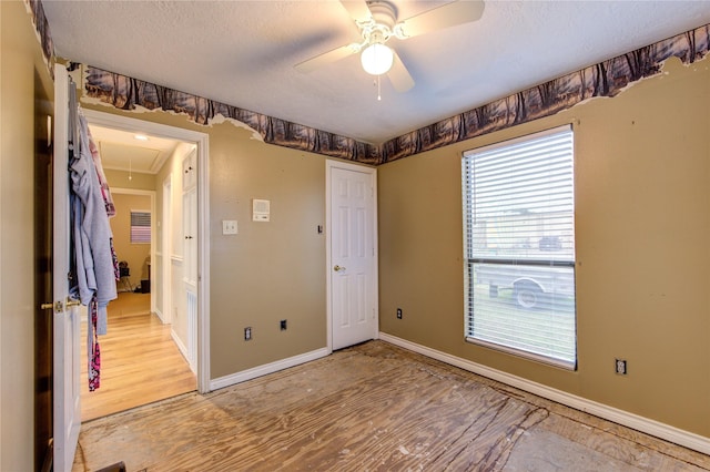 unfurnished bedroom with a textured ceiling, wood-type flooring, and ceiling fan