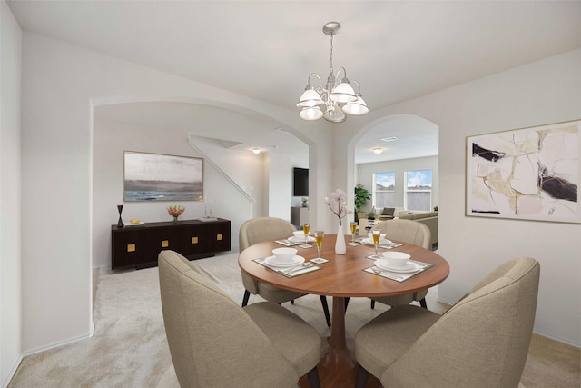 dining area with light carpet and an inviting chandelier