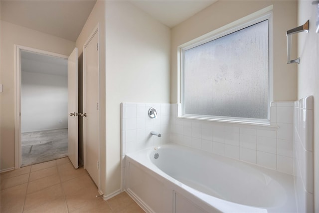 bathroom with tile patterned floors and a tub to relax in