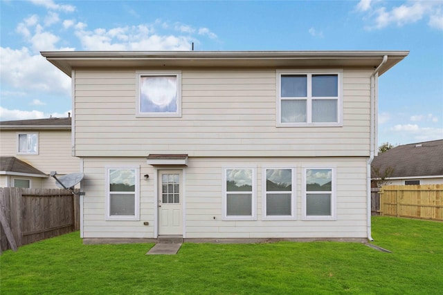 rear view of house featuring a lawn