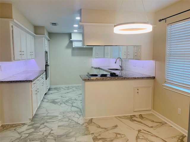 kitchen featuring sink, white cabinetry, tasteful backsplash, black oven, and dark stone counters