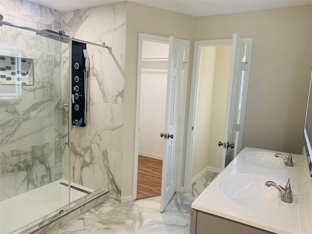 bathroom with tiled shower and vanity