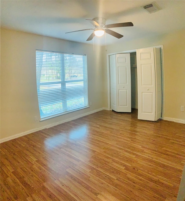 unfurnished bedroom featuring ceiling fan, a closet, and light wood-type flooring