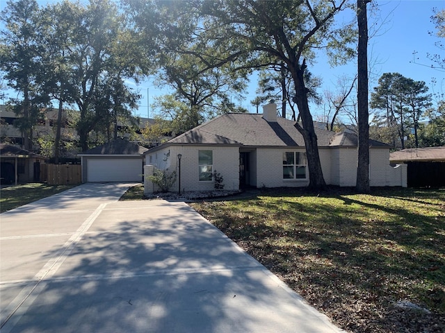 single story home featuring an outbuilding, a front lawn, and a garage