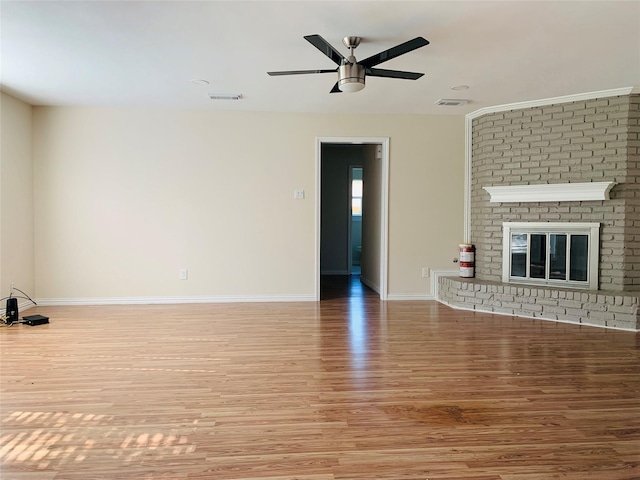 unfurnished living room with a brick fireplace, ceiling fan, and light hardwood / wood-style flooring