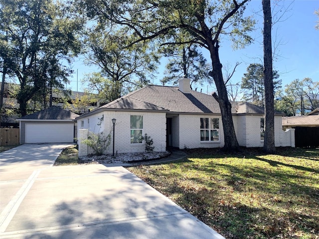 single story home with an outbuilding, a garage, and a front yard