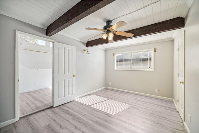 unfurnished bedroom featuring beam ceiling, ceiling fan, a closet, and light wood-type flooring