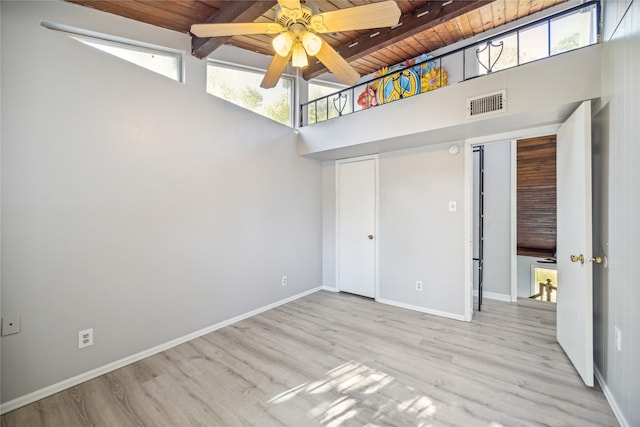 unfurnished bedroom with ceiling fan, light hardwood / wood-style flooring, wood ceiling, and a high ceiling