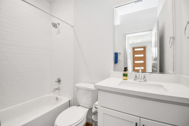 full bathroom featuring tiled shower / bath, vanity, and toilet