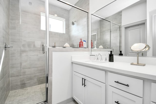 bathroom with vanity and a shower with shower door