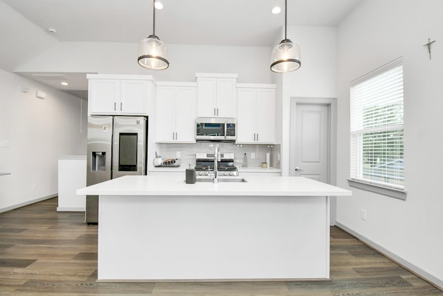 kitchen with stainless steel appliances, a kitchen island with sink, sink, pendant lighting, and white cabinetry