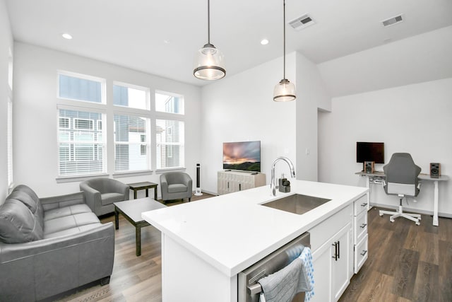 kitchen with stainless steel dishwasher, sink, a center island with sink, white cabinetry, and hanging light fixtures