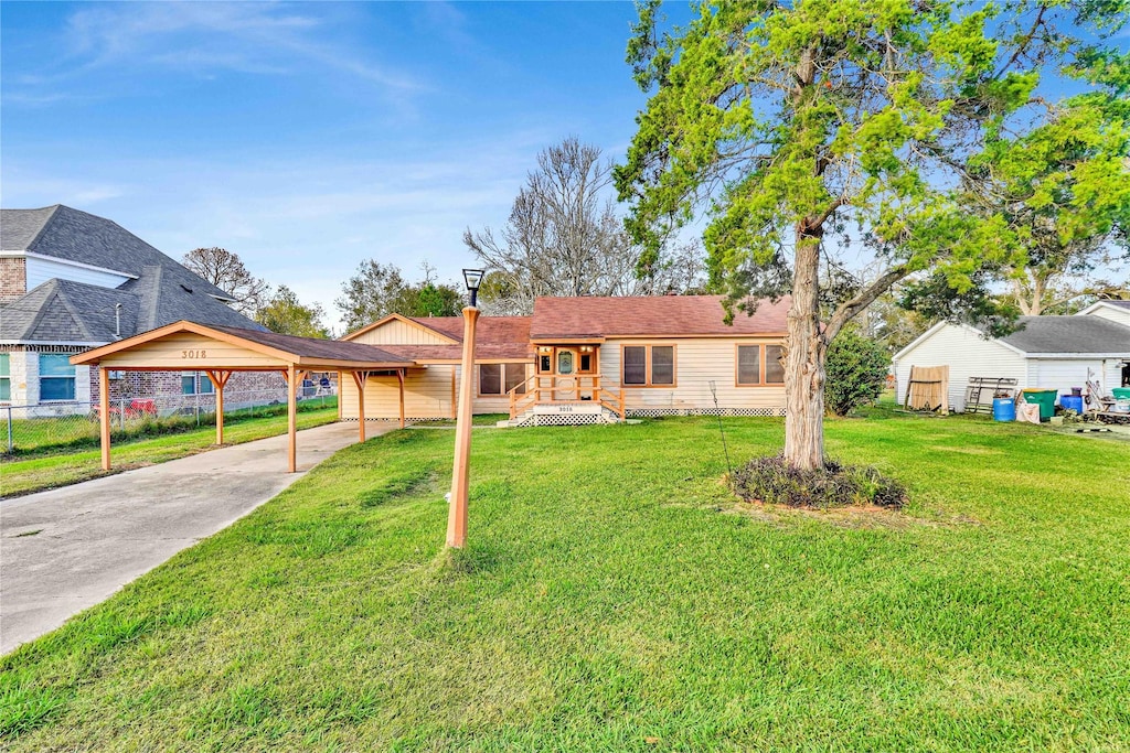 ranch-style house with a carport and a front lawn