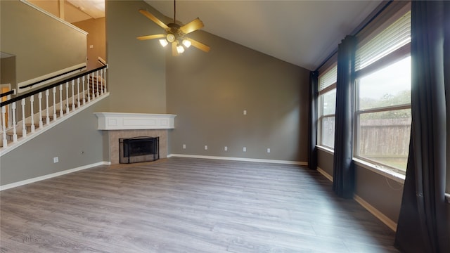 unfurnished living room featuring a fireplace, wood-type flooring, ceiling fan, and lofted ceiling