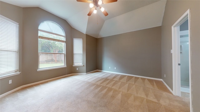 carpeted spare room featuring ceiling fan and vaulted ceiling