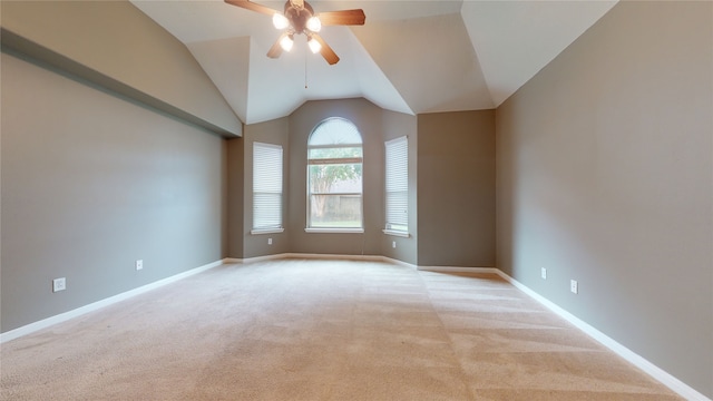 empty room featuring ceiling fan, light colored carpet, and lofted ceiling