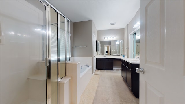 bathroom featuring vanity and independent shower and bath