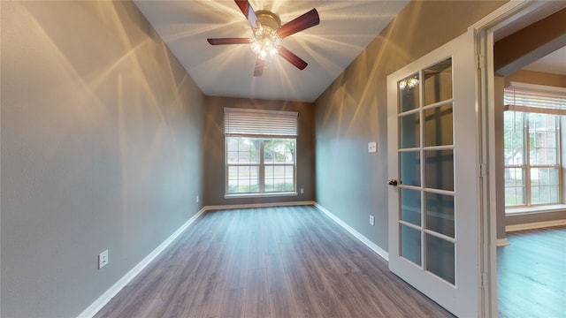 empty room with ceiling fan, french doors, and wood-type flooring