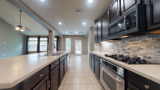 kitchen with sink, decorative backsplash, ceiling fan, light tile patterned floors, and appliances with stainless steel finishes